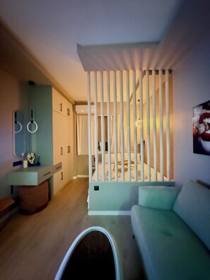 A modern interior with a sofa, a pet bed, a mirror, and a cabinet. - The secret muse a metro hub apartment in the center of Thessaloniki (Thessaloniki)