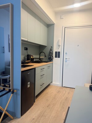 A compact kitchen with a dishwasher, a sink, and a countertop with a kettle. - The secret muse a metro hub apartment in the center of Thessaloniki (Thessaloniki)