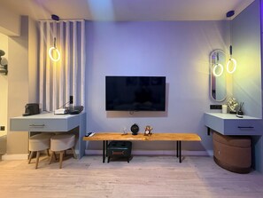 A modern living room with a flat-screen TV, two desks with ring lights, a bench, and a large mirror. - The secret muse a metro hub apartment in the center of Thessaloniki (Thessaloniki)
