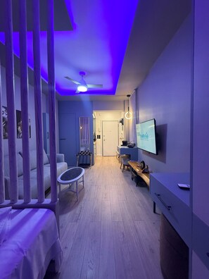 A modern living room with a sofa, a coffee table, and a TV mounted on the wall. - The secret muse a metro hub apartment in the center of Thessaloniki (Thessaloniki)