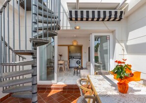 A modern interior with a spiral staircase, a dining area, and a kitchen visible through glass doors. - Penthouse with large private roof terrace - Calpe (Calp)
