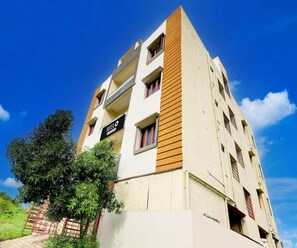 A multi-story hotel with a sign indicating it is a hotel. - Classic Akshaya Kannur (Penumuluru)