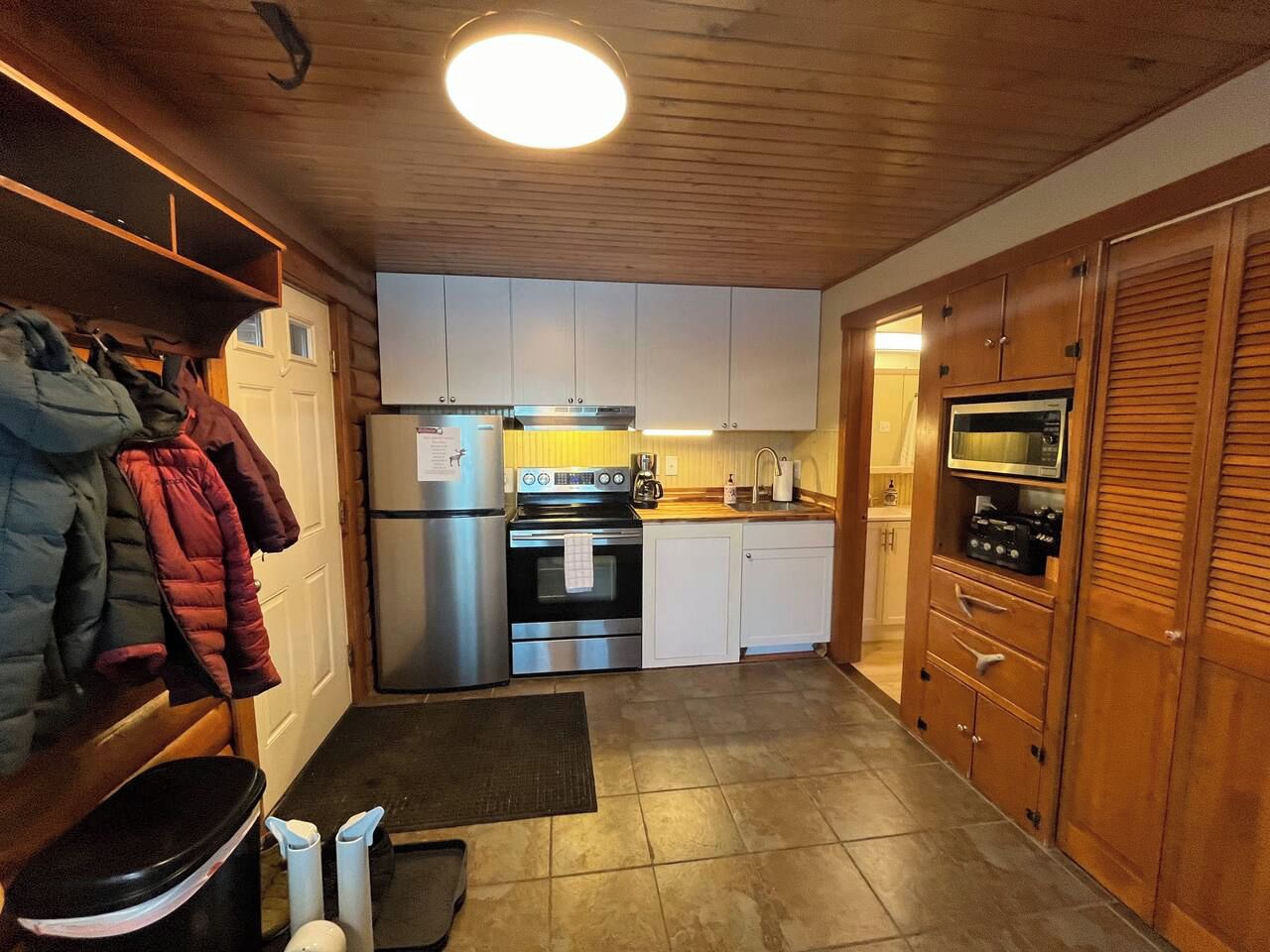 Een kleine keuken met een koelkast, fornuis, oven en magnetron.