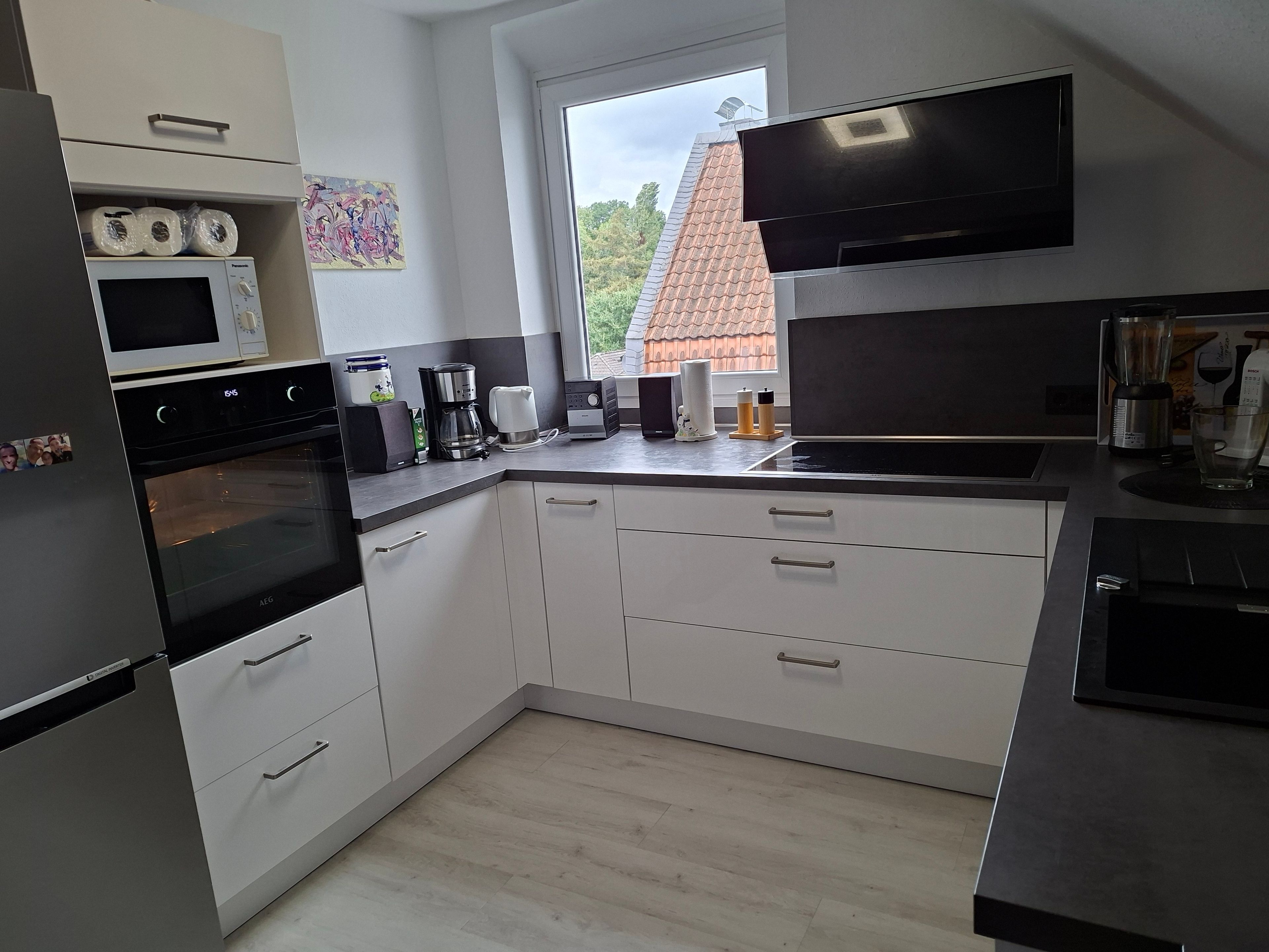 A modern kitchen with a built-in oven, microwave, and coffee maker.