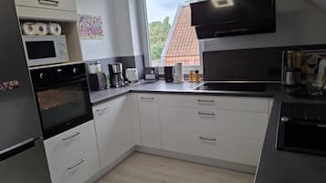 A modern kitchen with a built-in oven, microwave, and coffee maker.