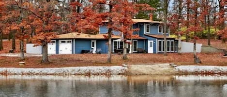 A two-story house with a blue exterior, a front porch, and a small front yard.