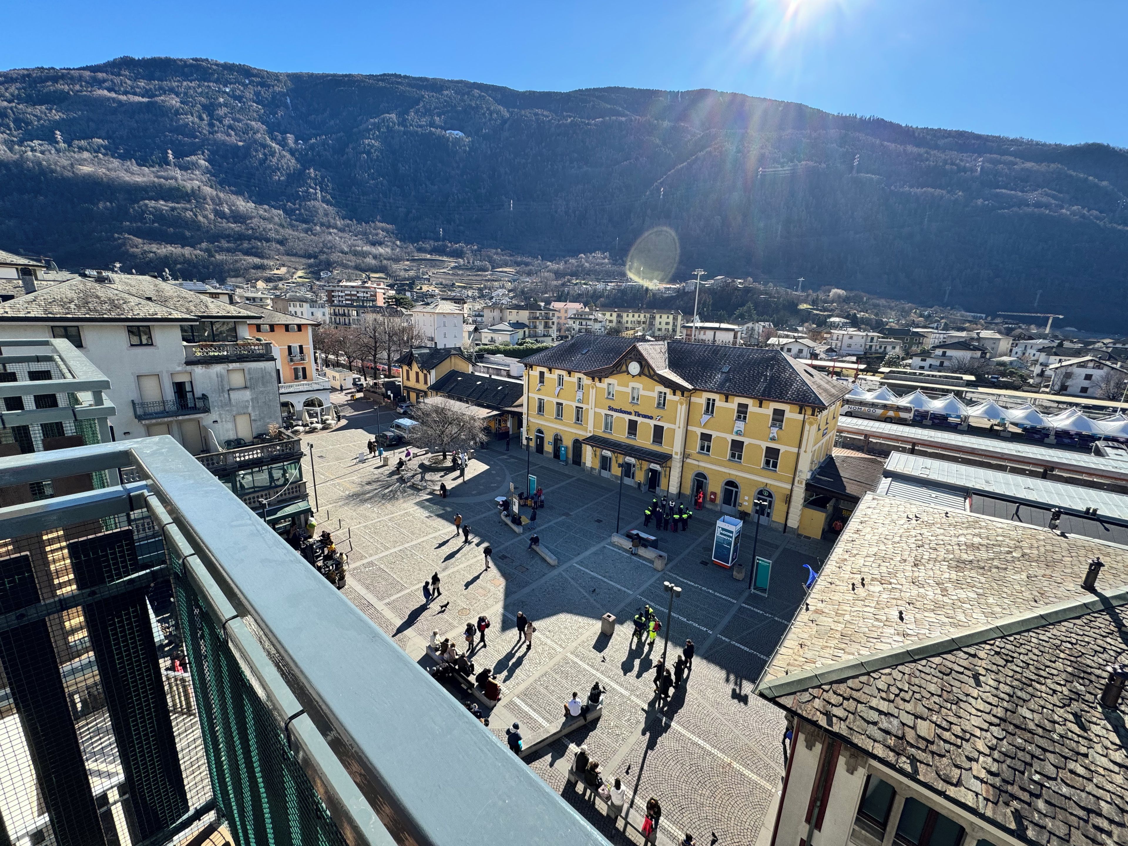 A town square with buildings, a central plaza, and a mountain backdrop.