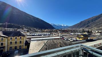 A mountainous town with a clear sky, a train station, and buildings with traditional architecture.
