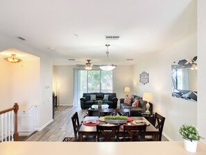 A dining area with a table set for four, a black leather sofa, and a ceiling fan. - Vista Cay Resort Orlando 3 Bed 3,5bath Townhouse (Orlando)