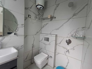 A bathroom with a toilet, sink, and shower. - Classic Mannat SRD (Varanasi)