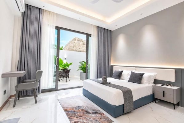 Un dormitorio moderno con una cama grande, mesitas de noche y vistas al exterior.