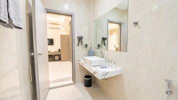 A modern bathroom with a white marble sink, a large mirror, and a shower.