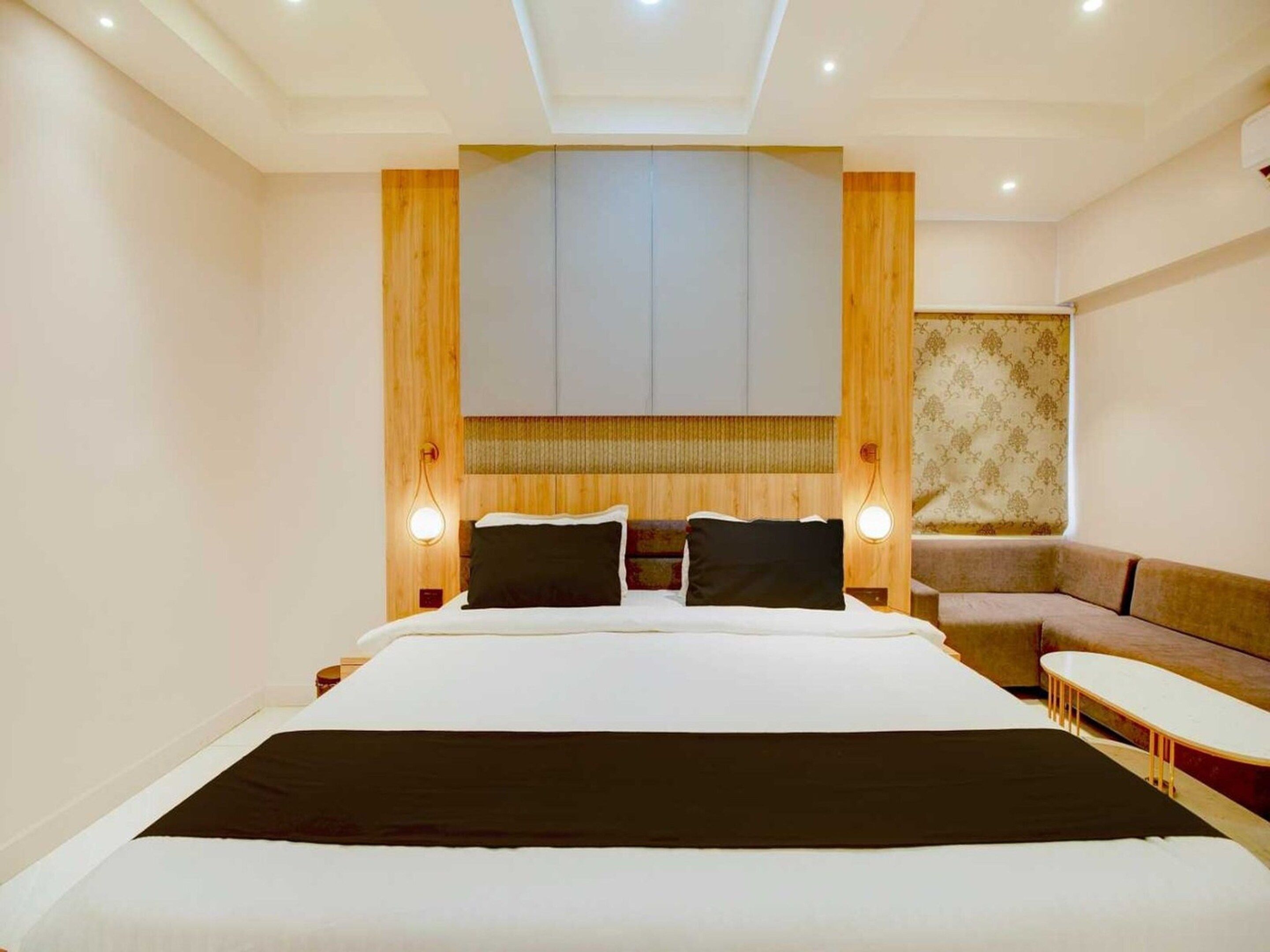 Una habitación de hotel con una cama grande, un sofá y una mesita.