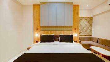 Una habitación de hotel con una cama grande, un sofá y una mesita.