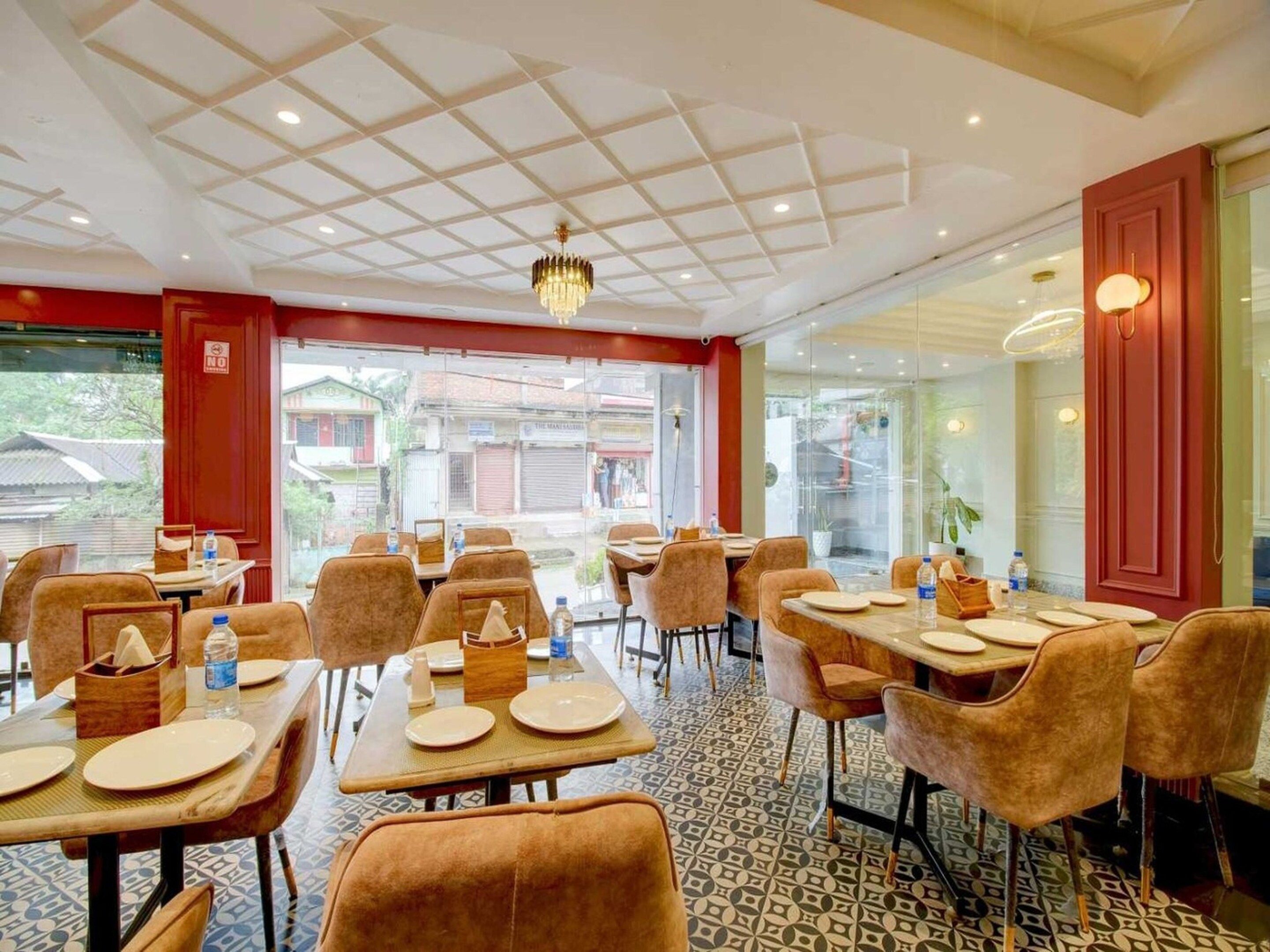 A restaurant with a grid-patterned ceiling, tables with chairs, and a view of the outside.