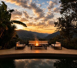 A poolside area with a fire feature and seating.