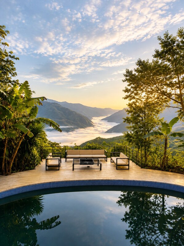 A pool area with a view of mountains and clouds.