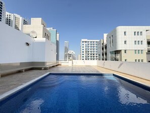 A rooftop swimming pool with a cityscape view, surrounded by modern buildings. - Comfort Stay - Walk Everywhere FJV46O (Manama)