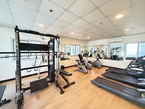 A gym with cardio equipment, weight machines, and mirrors. - Comfort Stay - Walk Everywhere FJV46O (Manama)