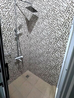 A bathroom with a shower, tiled walls, and a door. - Cozy 1-bedroom apartment in adorable Spintex with AC (Spintex)