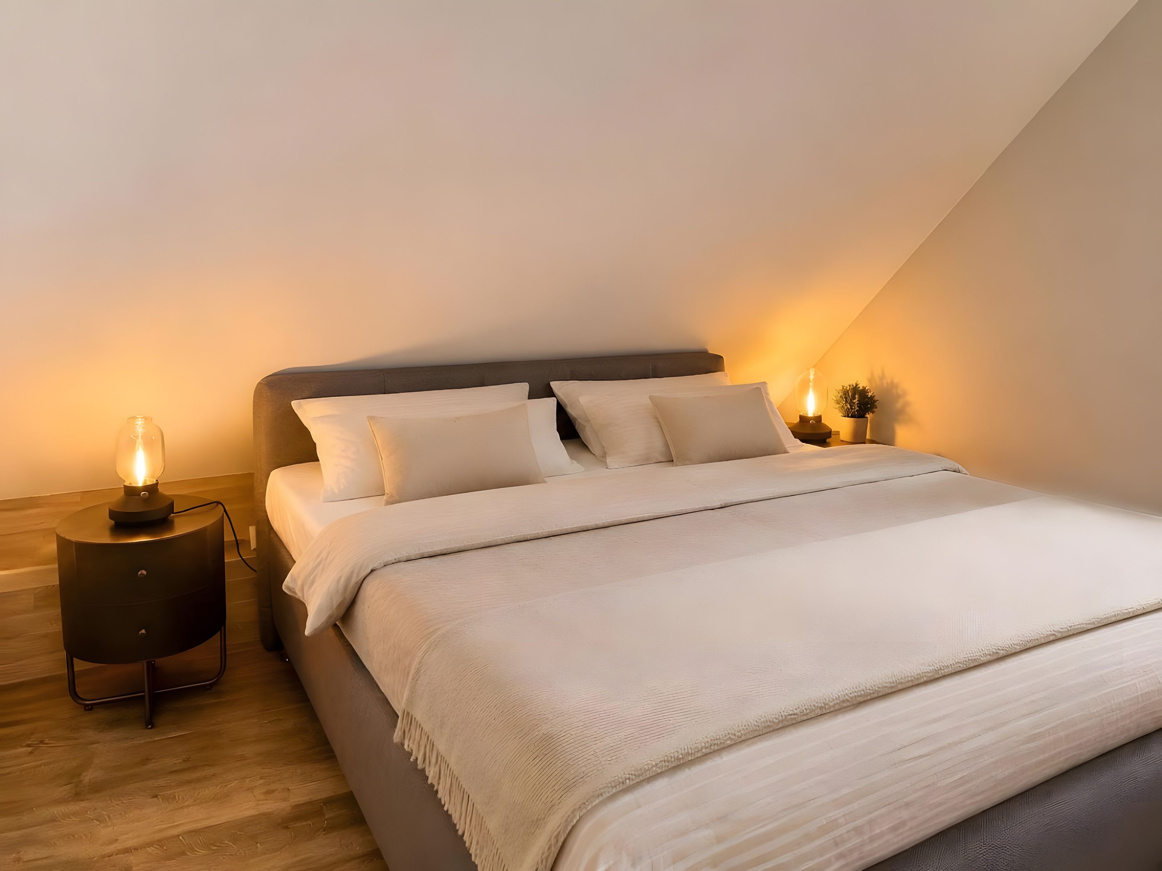 A bedroom with a bed, two bedside tables, and a nightstand with a lamp.
