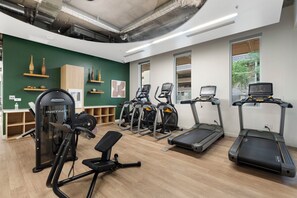A gym with various exercise equipment, including treadmills and elliptical machines. - Lovely 2BR | Pool + W/D | Near Arts District (Phoenix)