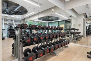 A gym with weightlifting equipment, treadmills, and exercise machines. - Lovely 2BR | Pool + W/D | Near Arts District (Phoenix)