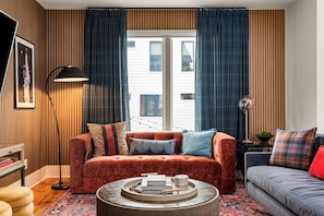 A living room with a red sofa, a grey sofa, a round coffee table, and a floor lamp. - Great Location Near Gulch, 12 South & Broadway (Nashville)