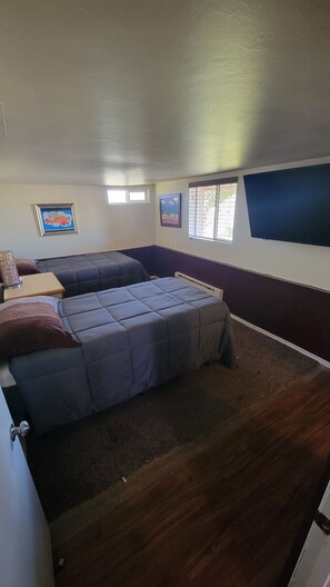 A compact room with two beds, a small table, and a window. - Perfect View 1-bedroom room with AC in delightful Grand Coulee (Grand Coulee)