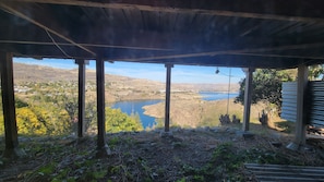 A covered outdoor area with a view of a lake and hills. - Perfect View 1-bedroom room with AC in delightful Grand Coulee (Grand Coulee)