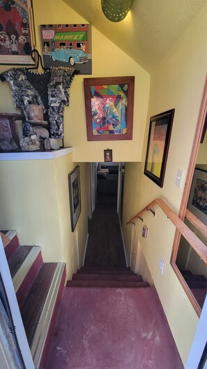 A staircase with a red carpet leading to a landing where a framed abstract painting is displayed. - Perfect View 1-bedroom room with AC in delightful Grand Coulee (Grand Coulee)