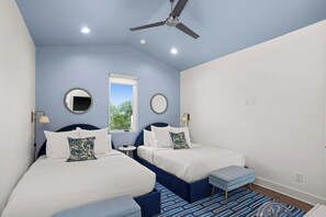 Ein Schlafzimmer mit zwei Betten, einem Deckenventilator und einem Fenster.
