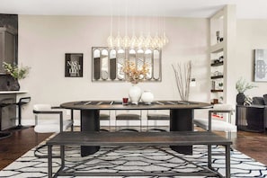A dining area with a round table, chairs, a chandelier, and a patterned rug. - Luxe Retreats Sleeps 24: Games, Views, Near Dwntwn (Nashville)