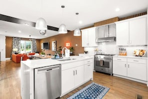 A modern kitchen with white cabinets, stainless steel appliances, and pendant lighting. - 10 Beds | Minutes to Broadway, Gulch & 12 South (Nashville)