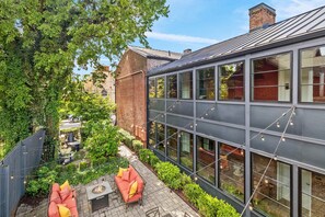 A modern building with large windows, a brick facade, and a courtyard with outdoor seating. - The Polk Suite | Germantown Inn | Breakfast (Nashville)