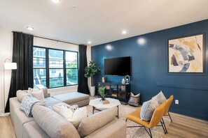 A modern living room with a sofa set, a coffee table, and a TV mounted on the wall. - 2 Mi to DT + King Beds & Garage (Nashville)