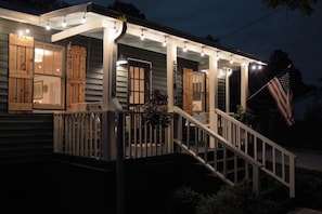A house with a porch, wooden shutters, and an American flag. - Leipers Fork Bungalow | Hot Tub & Firepit (Franklin)