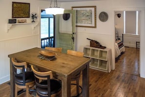 A dining area with a wooden table and chairs, a fan, and a map on the wall. - Leipers Fork Bungalow | Hot Tub & Firepit (Franklin)