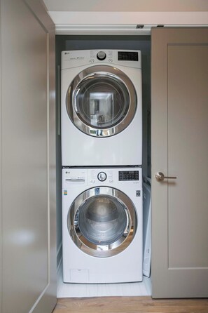 A compact laundry room with two stacked washing machines. - Rooftop, Grill, Garage, Near Broadway (Nashville)