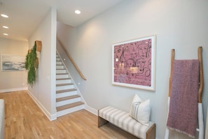 A staircase leading to a landing with a bench and a framed artwork on the wall. - Rooftop, Grill, Garage, Near Broadway (Nashville)