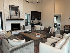 A living room with a fireplace, sofas, and a coffee table. - Luxury Franklin Farmhouse (Franklin)