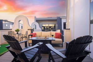 Une terrasse extérieure avec un canapé, des fauteuils et une table.