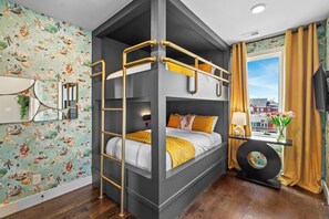 A bunk bed room with a city view, a mirror, and a small table with a lamp. - Disco Dream | 4BR Rooftop Sauna & Wellness Studio (Nashville)