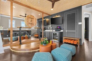 A modern living room with a wooden ceiling, a large mirror, and a TV mounted on the wall. - Disco Dream | 4BR Rooftop Sauna & Wellness Studio (Nashville)