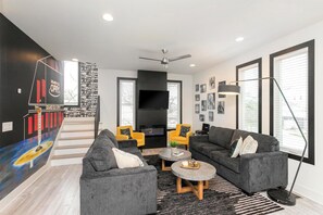A modern living room with a fireplace, sofas, a coffee table, and a TV. - The Grand Ole Opry Live! (Nashville)