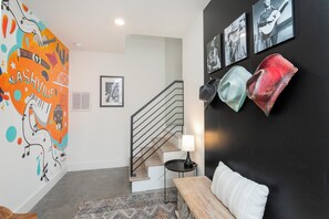 A modern interior with a staircase, a wall with framed pictures, and a colorful mural. - The Grand Ole Opry Live! (Nashville)