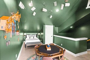 A room with a bed, a desk, and a chair. There is a door and a window. - 12 South | 7 Beds | 2mi to Broadway (Nashville)