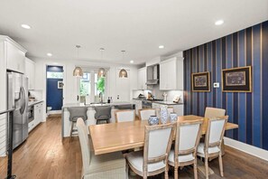 A modern kitchen with white cabinets, a central island, and pendant lighting. - 12 South | 7 Beds | 2mi to Broadway (Nashville)