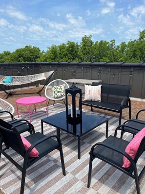 An outdoor patio area with a hammock, a round table, and a sofa. - Rooftop City Views, Garage, Near Broadway (Nashville)