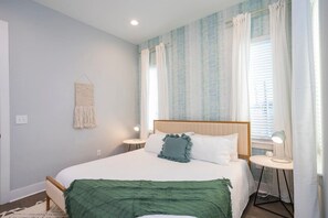 A neatly arranged bedroom with a bed, bedside tables, and a hanging macrame wall decoration. - 1 Mile to Downtown 4BR w/Rooftop (Nashville)